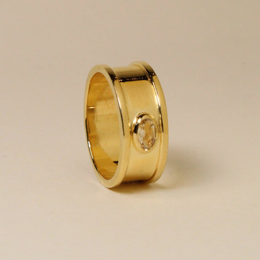 Gold ring on a beige background